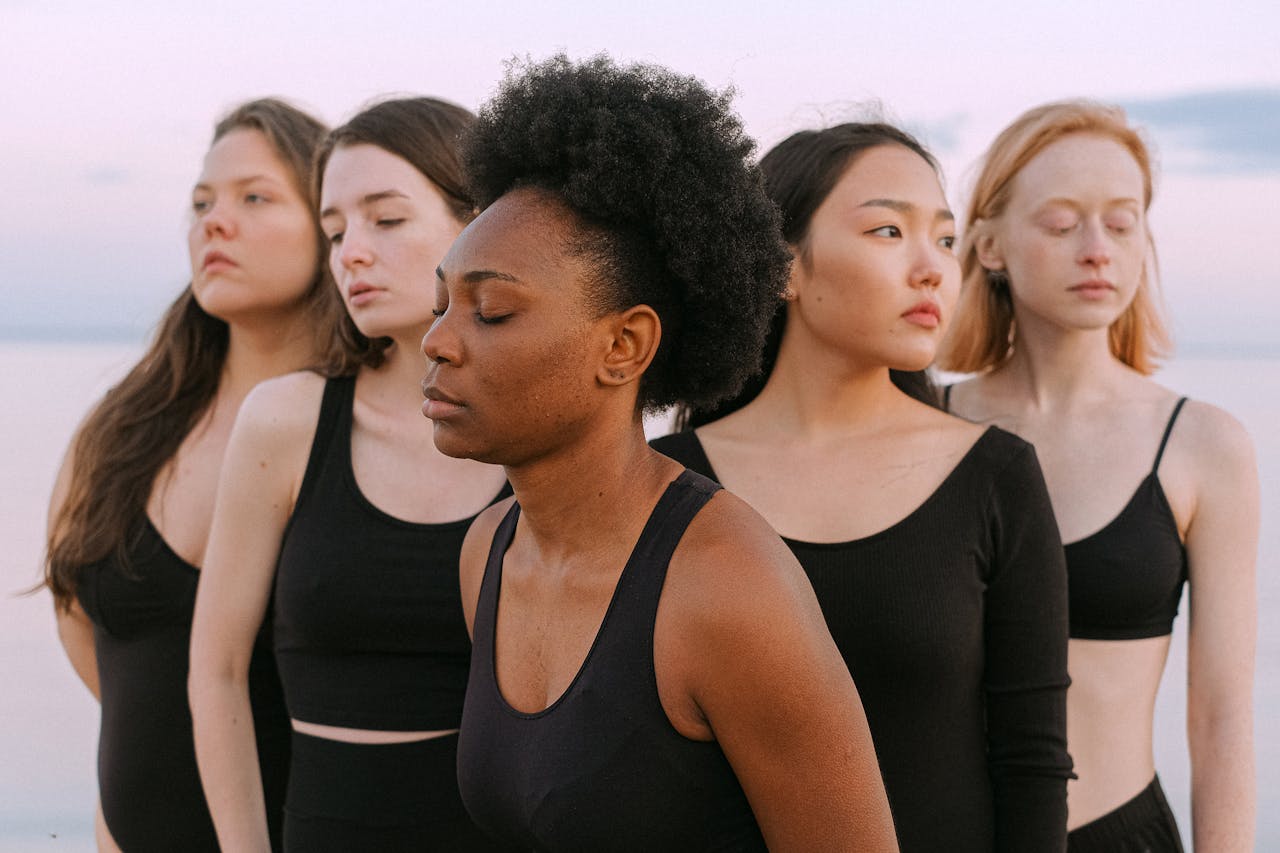 Five multicultural women standing together outdoors, symbolizing unity and diversity.